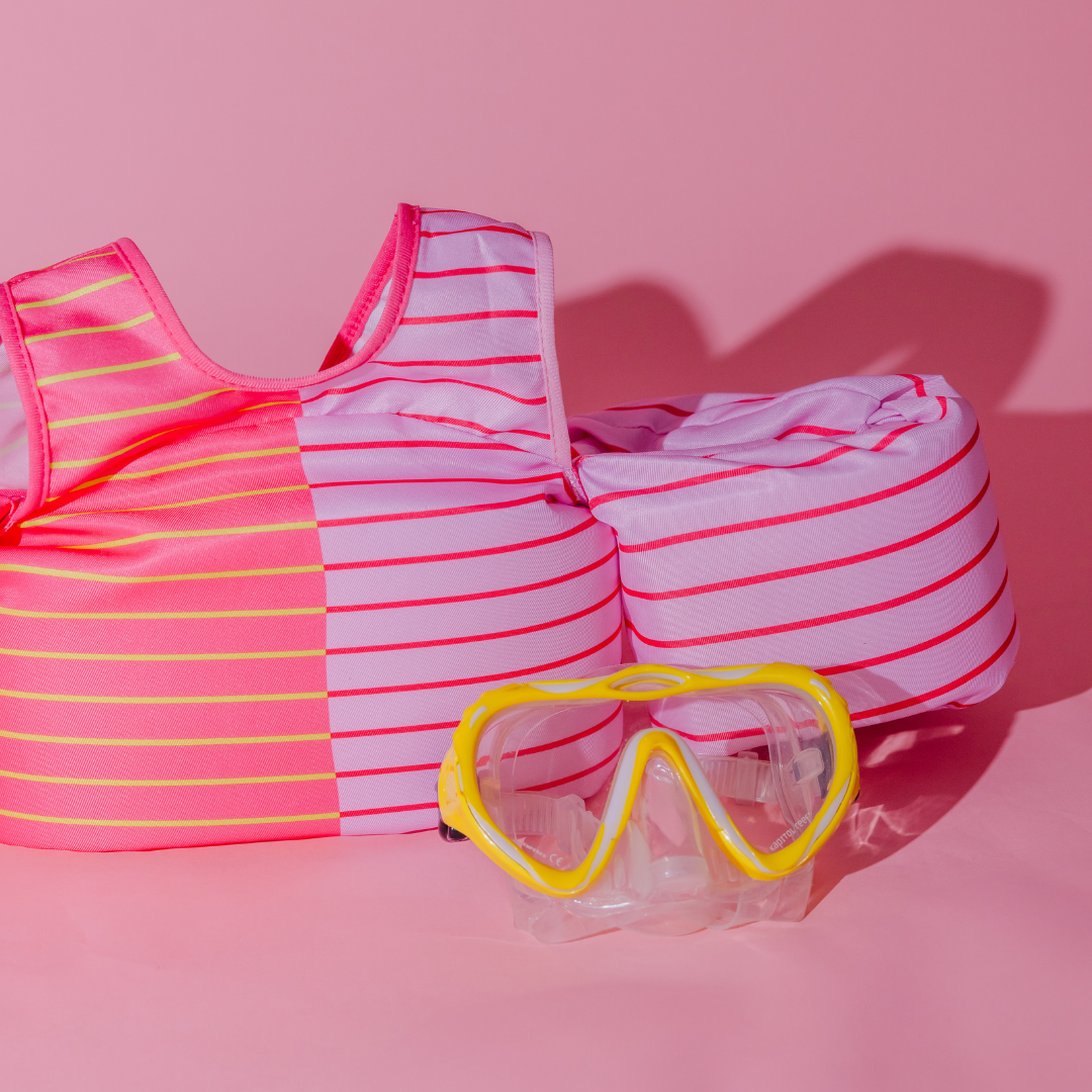 Pink Lemonade Stripe kids swim float with yellow swim goggles on pink background
