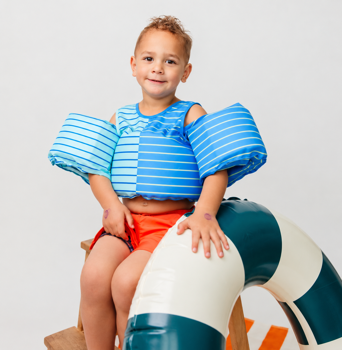 Child wearing a Drip Floats kids swim float showing chest and shoulder fit