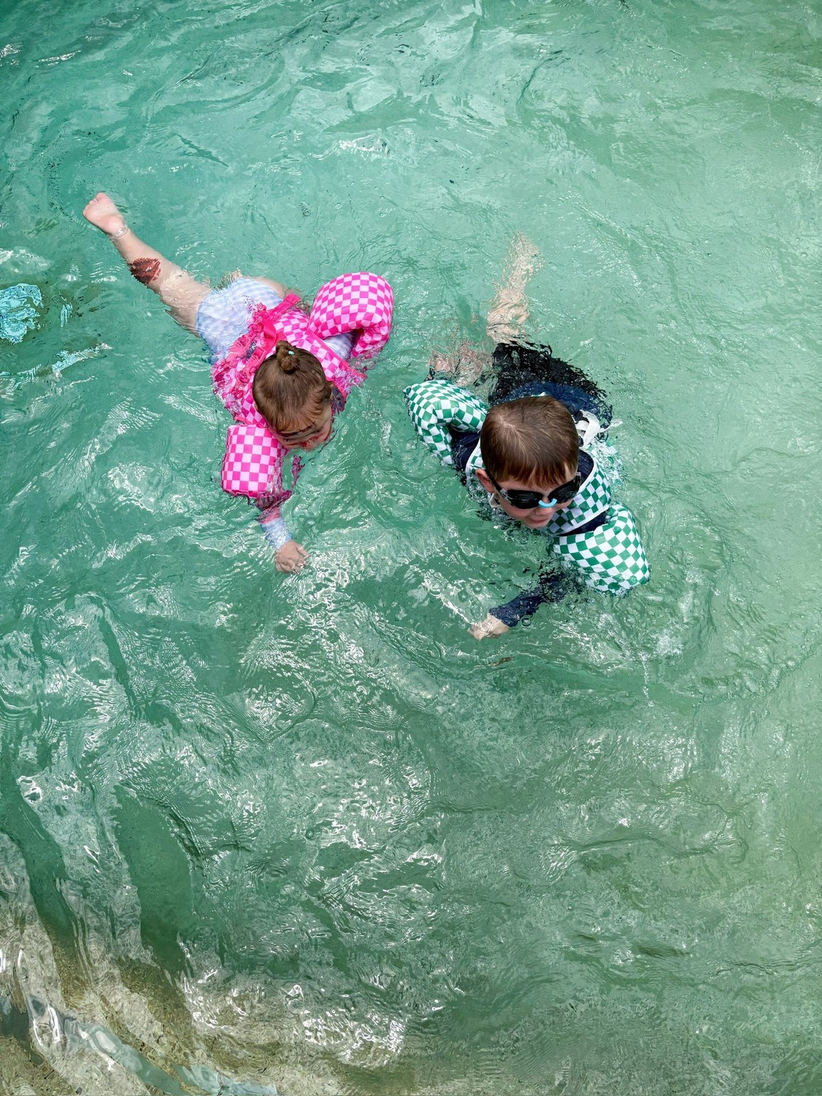 Child wearing a Drip Floats kids swim float during supervised pool time 