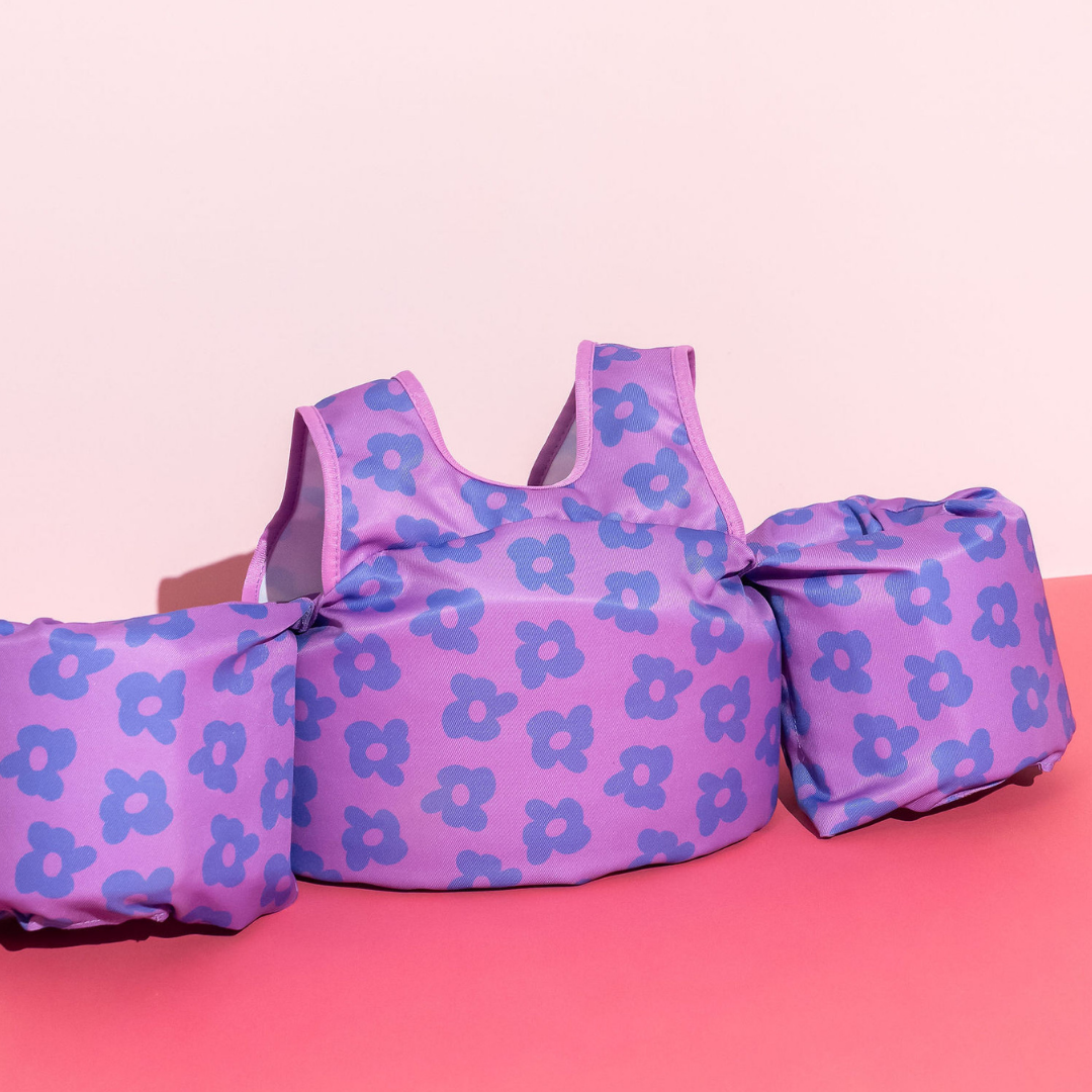 Purple Flower Power kids swim float with floral print on pink background