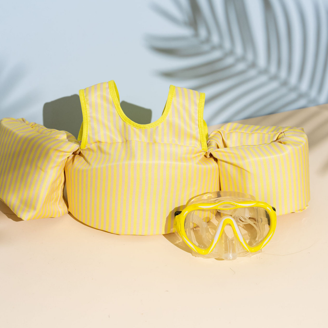 Yellow Stripe kids swim float with arm wings displayed poolside with yellow swim goggles